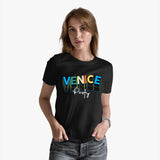 A woman wearing a black crew neck t-shirt with 'VENICE party' printed in colorful letters across the chest.