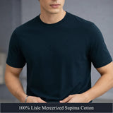 Man wearing a deep navy t-shirt with text about fabric composition on a gray background