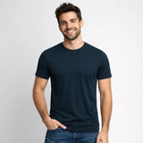 Man wearing a navy blue t-shirt against a light gray background
