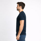 Man wearing a navy blue t-shirt and jeans on a white background