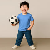 Child holding a soccer ball against a plain background