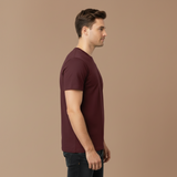 Man wearing a maroon t-shirt against a beige background