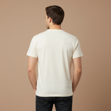 Man wearing a plain white t-shirt against a beige background